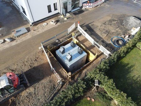 fertig eingesetzte Müllbehälter in den Betonboxen, in Baugrube mit Verbau